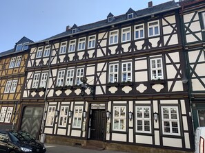 A traditional half-timbered building with multiple windows, a door, and a sign indicating a restaurant. - Hotel Goldene Krone (Goslar)