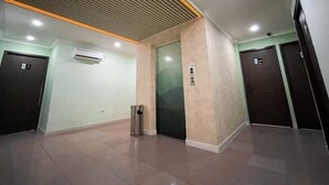 Un interior moderno con suelo de baldosas, techo con lámpara lineal y dos puertas numeradas.