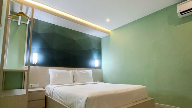 Un dormitorio moderno con una cama, mesitas de noche y una lámpara colgante.