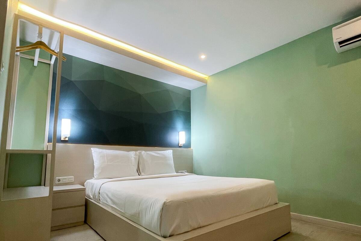 Een moderne slaapkamer met een bed, nachtkastjes en een hanglamp.