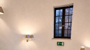 A staircase with a curved wall, two windows, and wall-mounted lights. - Sleephotels Suite Garde (Hamburg)
