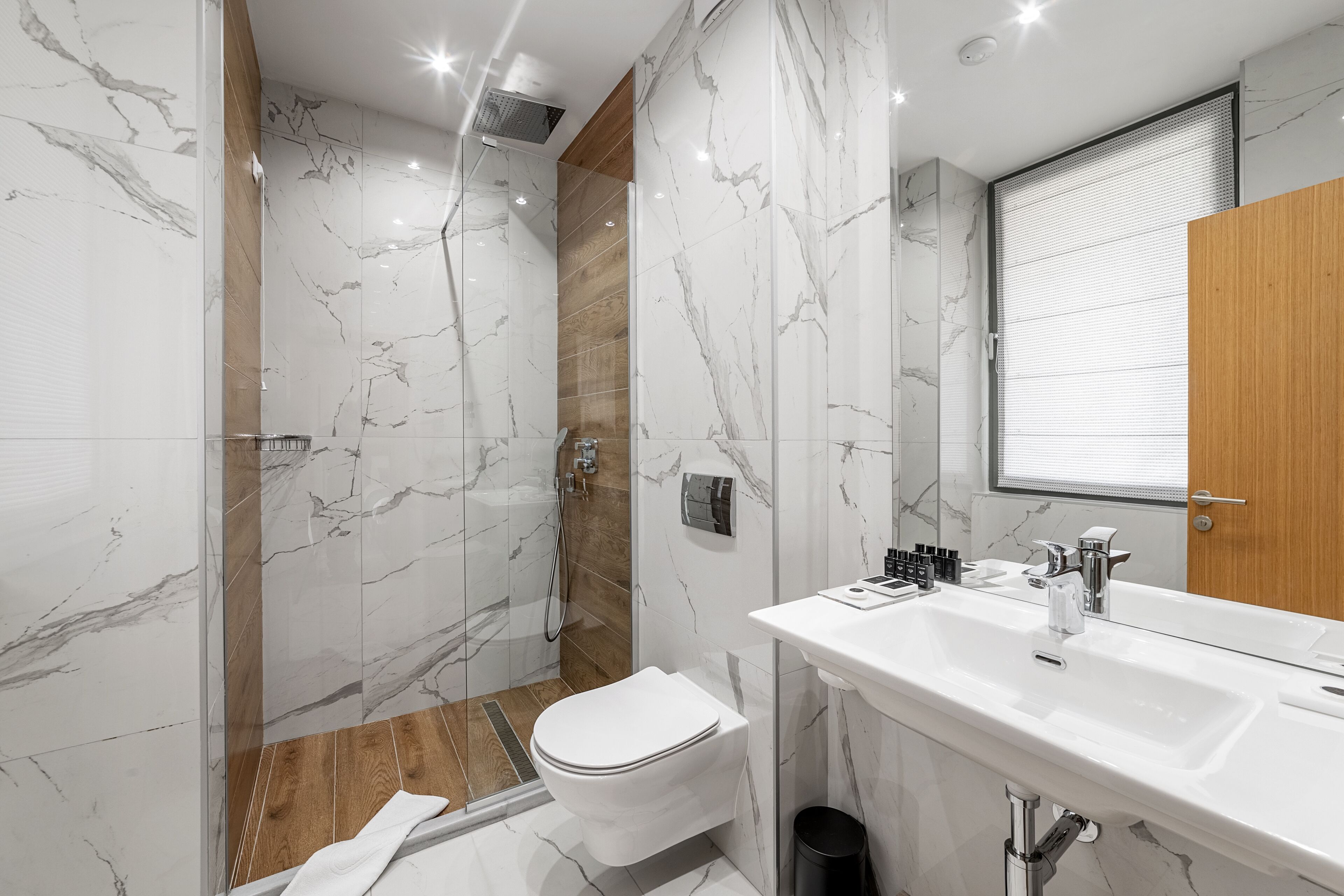 Een moderne badkamer met douche, toilet en wastafel.