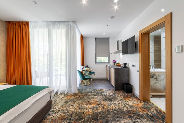 Une chambre d’hôtel comprenant un lit, un bureau avec une chaise, une télévision et une salle de bain.