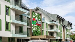 Un hôtel moderne doté d’une enseigne de jardin bien visible, de nombreux balcons et d’une architecture contemporaine.