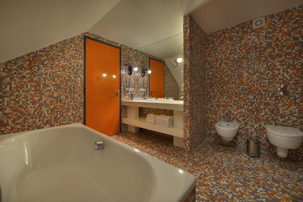 Un baño con una bañera grande, dos lavamanos y un salpicadero de azulejos.