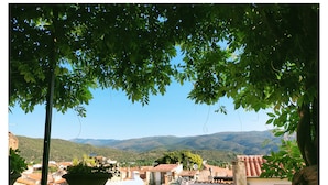 A view of a town with terracotta rooftops, surrounded by greenery and hills. - La Belle D'Âme (Prades)