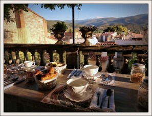 A table set for breakfast with croissants, bread, and a jar of nuts, overlooking a mountainous landscape. - La Belle D'Âme (Prades)