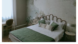A bedroom with a bed, a chair, a nightstand, and a lamp. - La Belle D'Âme (Prades)