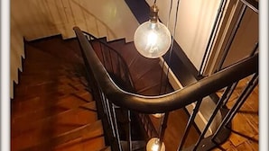 A staircase with a modern design, featuring a metal railing and a hanging light fixture. - La Belle D'Âme (Prades)