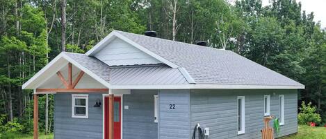 A single-story cabin with a gabled roof, a small porch, and a number '22' on the side.