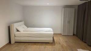 A bedroom with a bed, a wardrobe, and a curtain. - Romantic Luxury appartment in the heart of Grachen (Grächen)