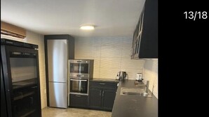 A compact kitchen with a refrigerator, oven, and microwave. - Romantic Luxury appartment in the heart of Grachen (Grächen)