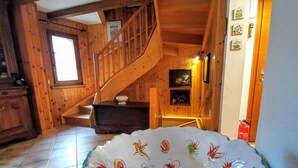 Un interno in legno con una scala, un caminetto e una piastra decorativa con carte da gioco.
