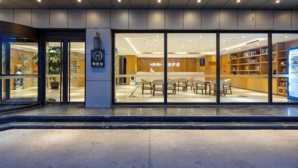 A modern interior with a reception desk, seating area, and bookshelves. - Starway Hotel (Beijing Yanqi Development Zone) (Beijing)