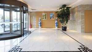 A lobby with a marble floor, a glass entrance, and a potted plant. - Starway Hotel (Beijing Yanqi Development Zone) (Beijing)