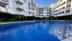 A swimming pool surrounded by modern white buildings with balconies. - Lovely flat with beautiful views AV-32 (Roses)