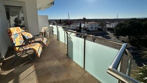 A balcony with a view of the city, a chair, and a table. - Lovely flat with beautiful views AV-32 (Roses)