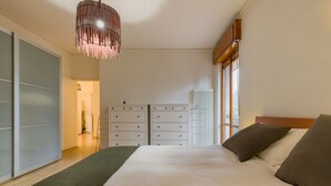 A bedroom with a large bed, a wardrobe, a dresser, and a hanging light fixture. - Alle mura apartment (Verona)