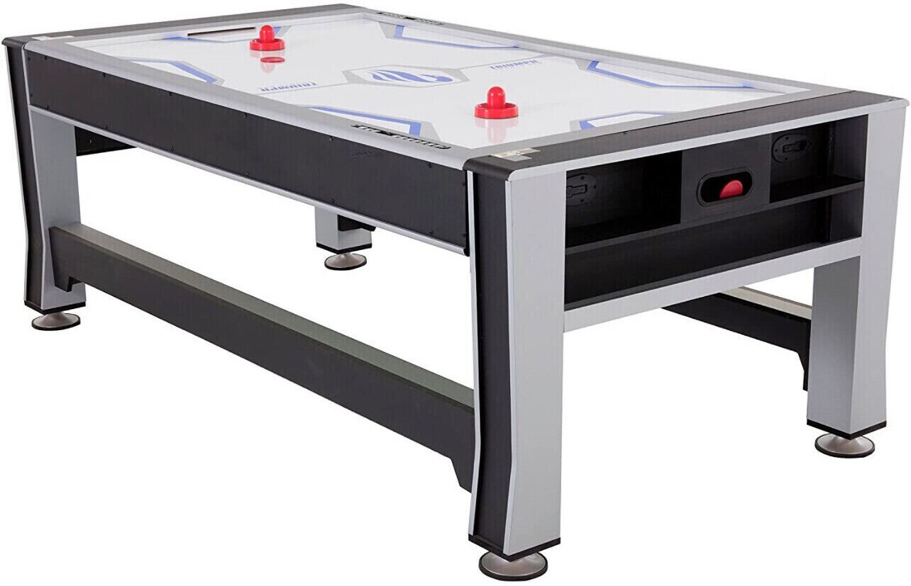 Un juego de hockey de mesa con superficie de vidrio y estructura metálica, con controles rojo y azul.