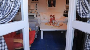 A cozy room with a bed, a desk, and a window with curtains. - Dandy Villas Velanidia Sailor's House - Private Maisonette - Sea View (Velanidia)