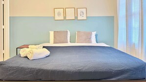 A neatly made bed with a gray quilt, two pillows, and a folded towel on the side. There are three framed quotes on the wall above the bed. - 2 Bed 2.5 Bath Townhome in Norcross (Gwinnett County) (Norcross)