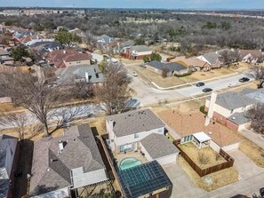 A residential area with houses, a swimming pool, and a solar panel installation. - Spacious 5BR/2.5B Home with Pool (Grand Prairie)