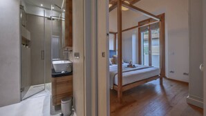 Une salle de bain moderne avec une douche à parois de verre, un meuble-lavabo en bois et un grand miroir.