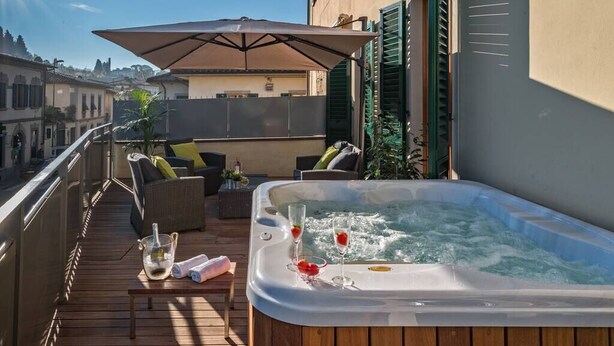 Un balcon doté d’un jacuzzi, de mobilier d’extérieur et offrant une vue sur la ville.