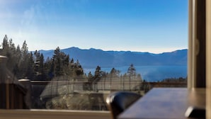 A view from a window overlooking a mountainous landscape with a lake and trees. - Scenic Escape - Best Views of Lake Tahoe! (Stateline)