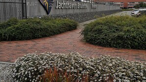 Un chemin menant à un bâtiment sur lequel on peut lire l’inscription « Jachthaven Brunnisse ».