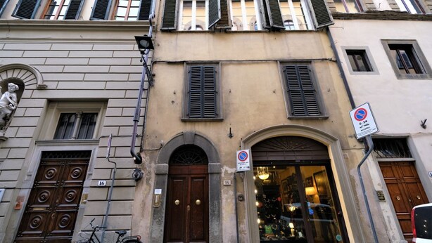 A building with a large wooden door, a bicycle parked outside, and a 'No Parking' sign. - Wine Apartments Florence Ciliegiolo  (Firenze)