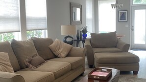 A living room with a beige sofa, a matching armchair, and a wooden coffee table. - Breath and Relax/can sleep up to 6 guest/pets ok (Bluffton)