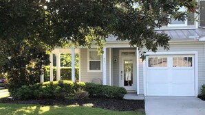 A two-story house with a front porch, a garage, and a well-maintained lawn. - Breath and Relax/can sleep up to 6 guest/pets ok (Bluffton)