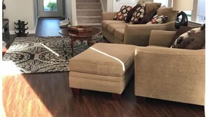 A living room with a beige sofa set, a patterned rug, and a wooden floor. - Breath and Relax/can sleep up to 6 guest/pets ok (Bluffton)