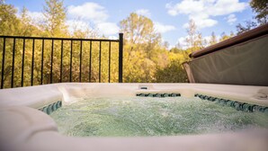 Un jacuzzi con vista a árboles y cielo despejado.