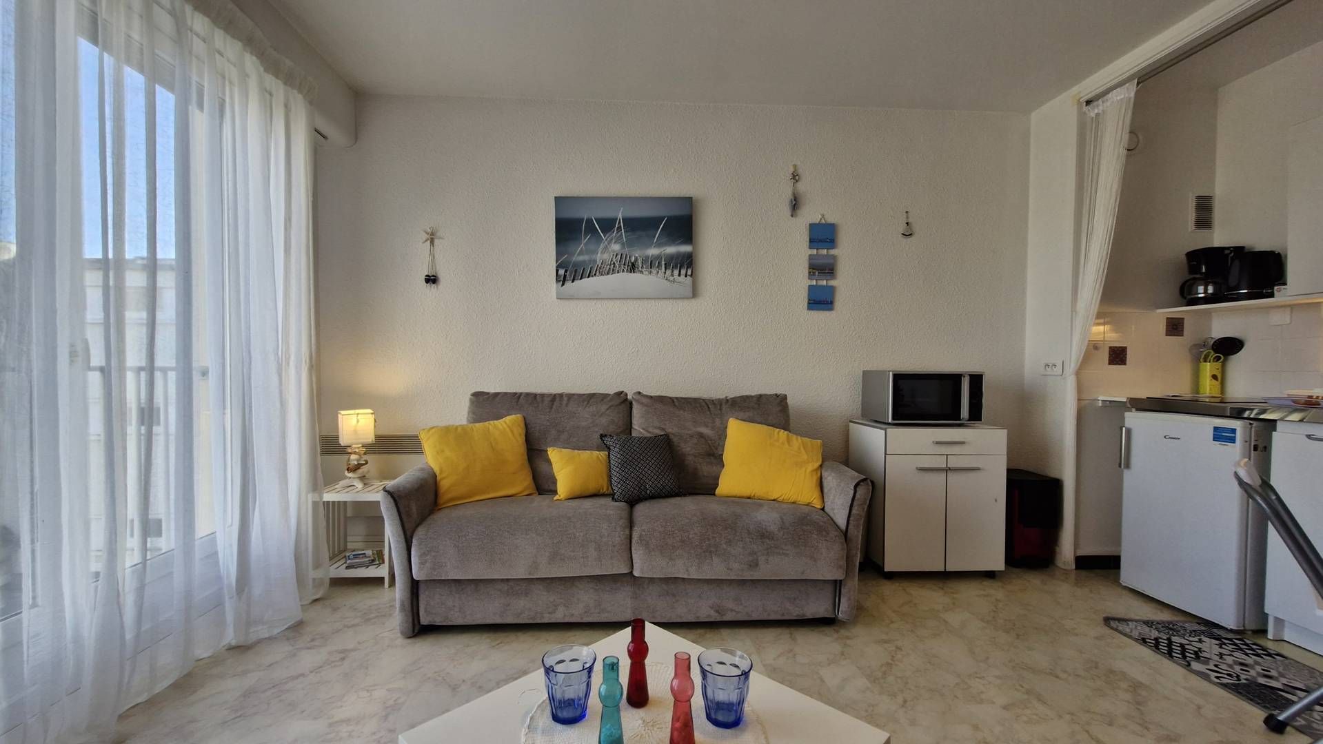 Een knus woongedeelte met een bank, een kleine televisie en een kitchenette.
