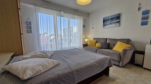 Een slaapkamer met een bed, een bank en een nachtkastje.