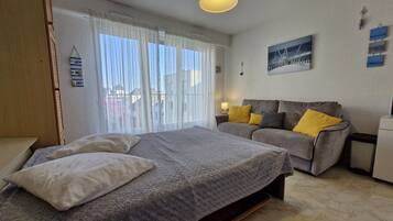 Um quarto com uma cama, um sofá e uma mesa de cabeceira.
