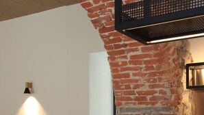 A wooden table with a brick wall and a metal shelf in the background. - Charme Hotel al Torchio  (Ascona)