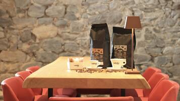 A wooden table with two coffee bags, a coffee cup, and a lamp.