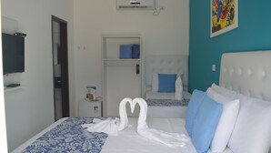 Habitació d'hotel amb llit, armari, televisió i aire condicionat fixat a la paret.