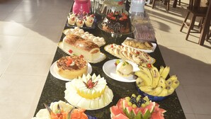 A buffet with various food items and a beverage station. - Pousada Vovó Zilda (Maragogi)