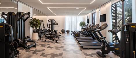 A modern gym with various exercise equipment, including treadmills, weight machines, and free weights.