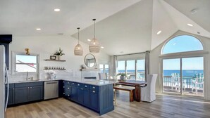 A spacious kitchen with a large island, modern appliances, and a view of the ocean. - Remodeled Oceanfront w/ Hot Tub, 2 Decks, Walk to Surf City Pier, Pet-Friendly (Surf City)