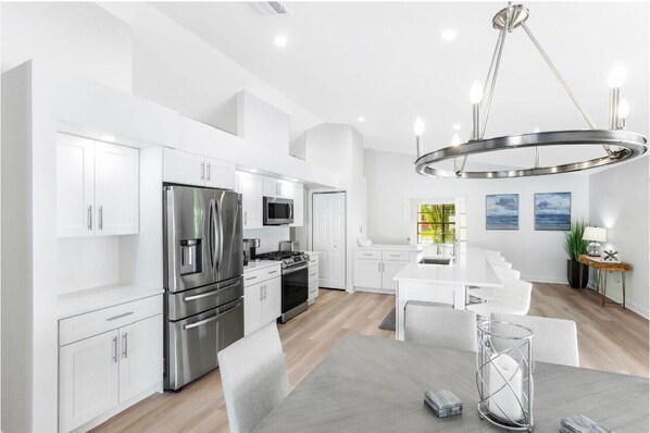 Enjoy cooking in this well-equipped kitchen with stainless steel appliances, a central island, and ample dining space.