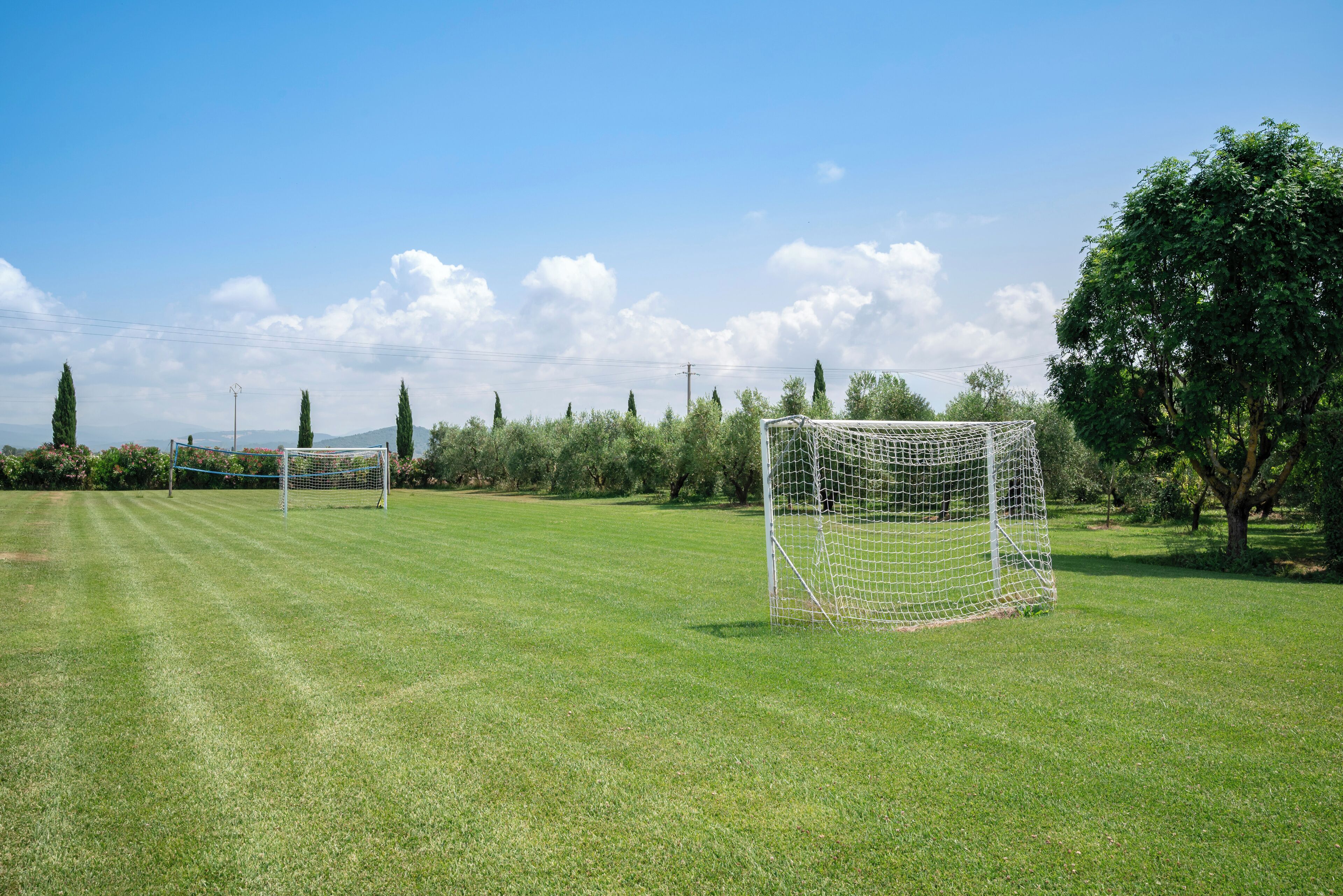 Un campo de fútbol con dos porterías y un cielo despejado.