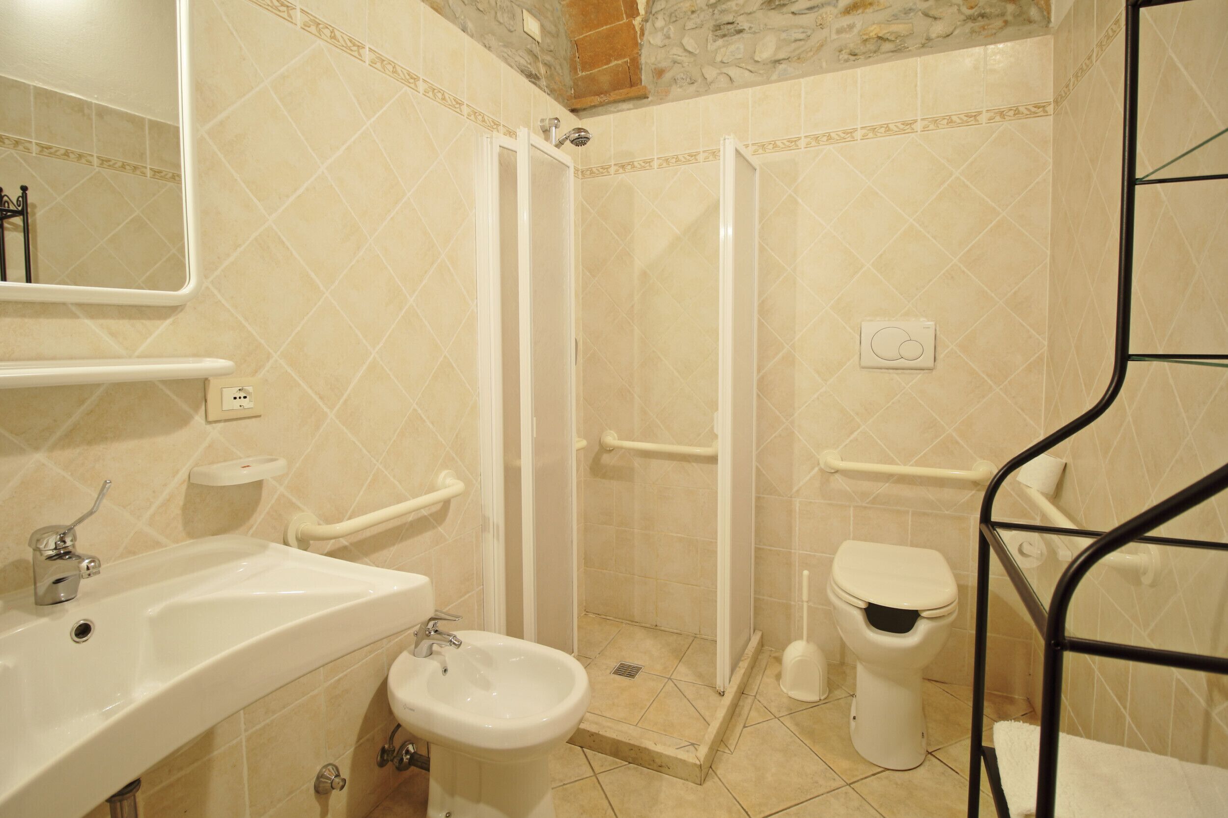 A bathroom with a sink, bidet, toilet, and glass shower enclosure.