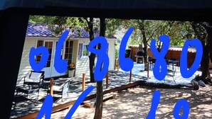 Un quartier résidentiel avec une maison, du mobilier d’extérieur et un arbre.