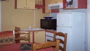 Une cuisine compacte équipée d’un évier, d’un four à micro-ondes, d’une cuisinière et d’un réfrigérateur.