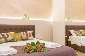 A hotel room with a large bed, multiple pillows, a bedside table, and a mirror. - Casa Al Volto (Verona)